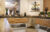 Detailaufnahme eines Buffetbereichs der FHE GASTRO mit Holz- und Steinverkleidung, verschiedenen Speisen und Dekorationen wie Figuren und Blumenarrangements.