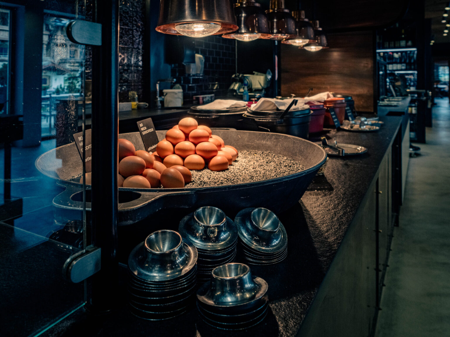 BUFFET_Forsthofgut-April_2024-237-HDR Gastronomische Frühstückstheke mit frischen Bio-Eiern, serviert in einer stilvollen Pfanne. Die Theke ist mit modernen Küchengeräten und eleganten Details ausgestattet, perfekt für Buffet-Lösungen in Hotels und Restaurants. FHE GASTRO bietet maßgeschneiderte Gastronomieeinrichtungen für jeden Bedarf.