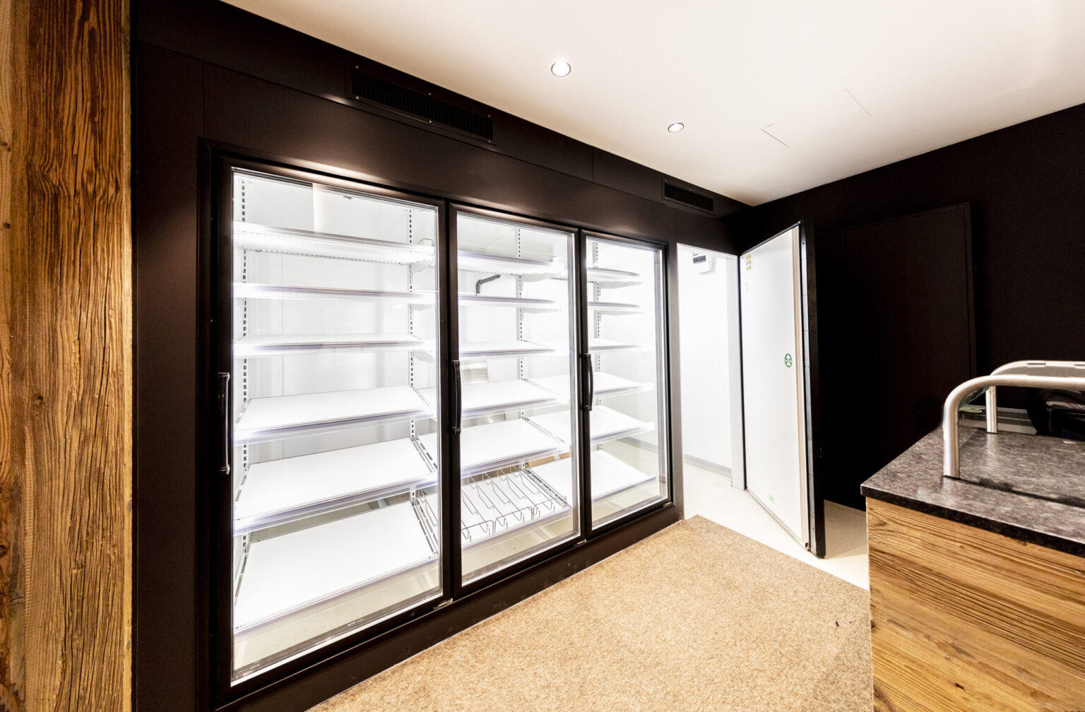 Hochhäderich_Kühlraum 5 Kühlraum in Hochhäderich von FHE GASTRO - Großer, professioneller Kühlraum mit Edelstahlregalen und einer robusten Tür für den Einsatz in der Gastronomie zur Lagerung und Präsentation frischer Produkte.