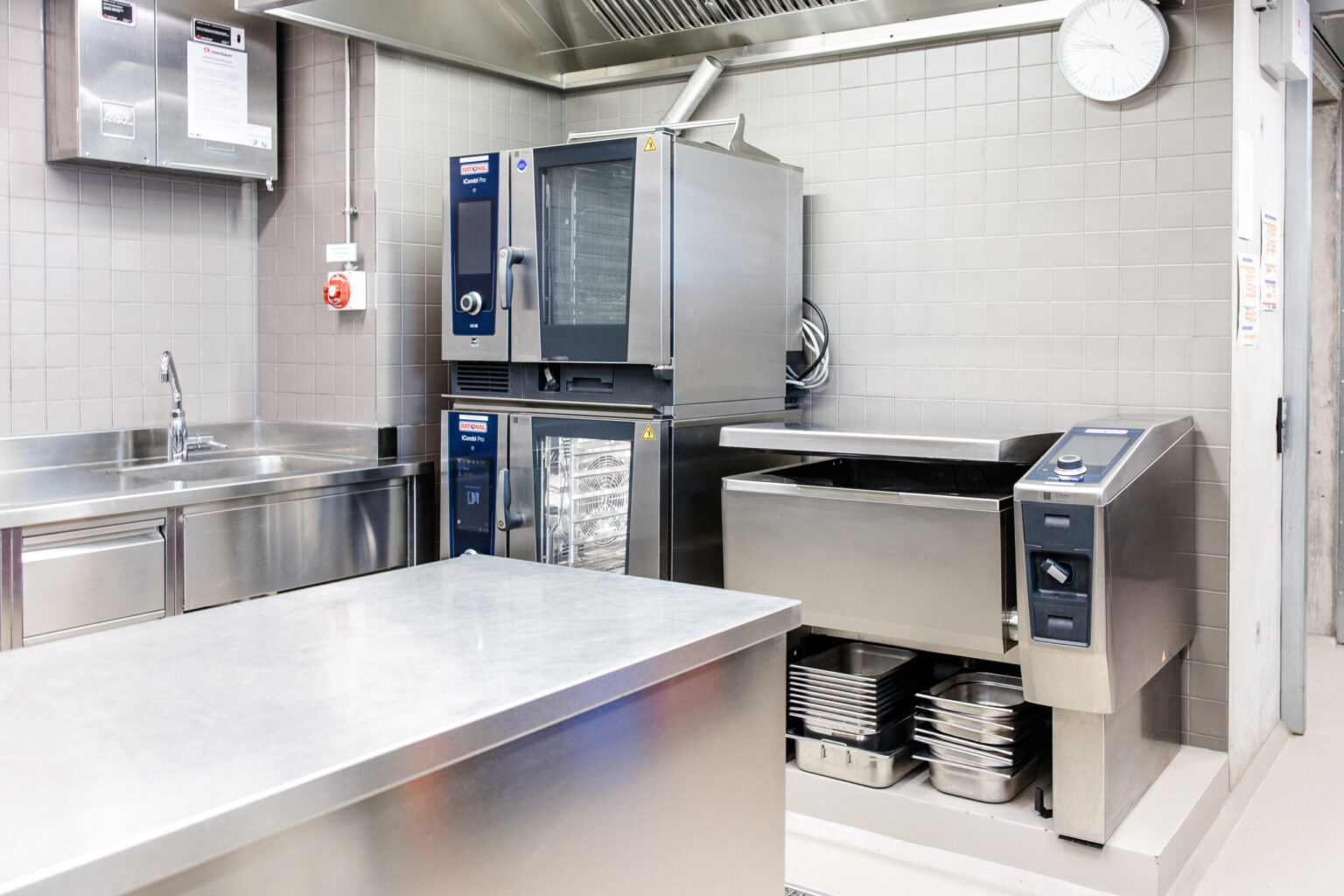 Komplett ausgestattete Profiküche von FHE GASTRO mit Geräten von RATIONAL. Die Geräte bieten vielseitige Funktionen für Dämpfen, Backen und Braten, ideal für den flexiblen Einsatz.