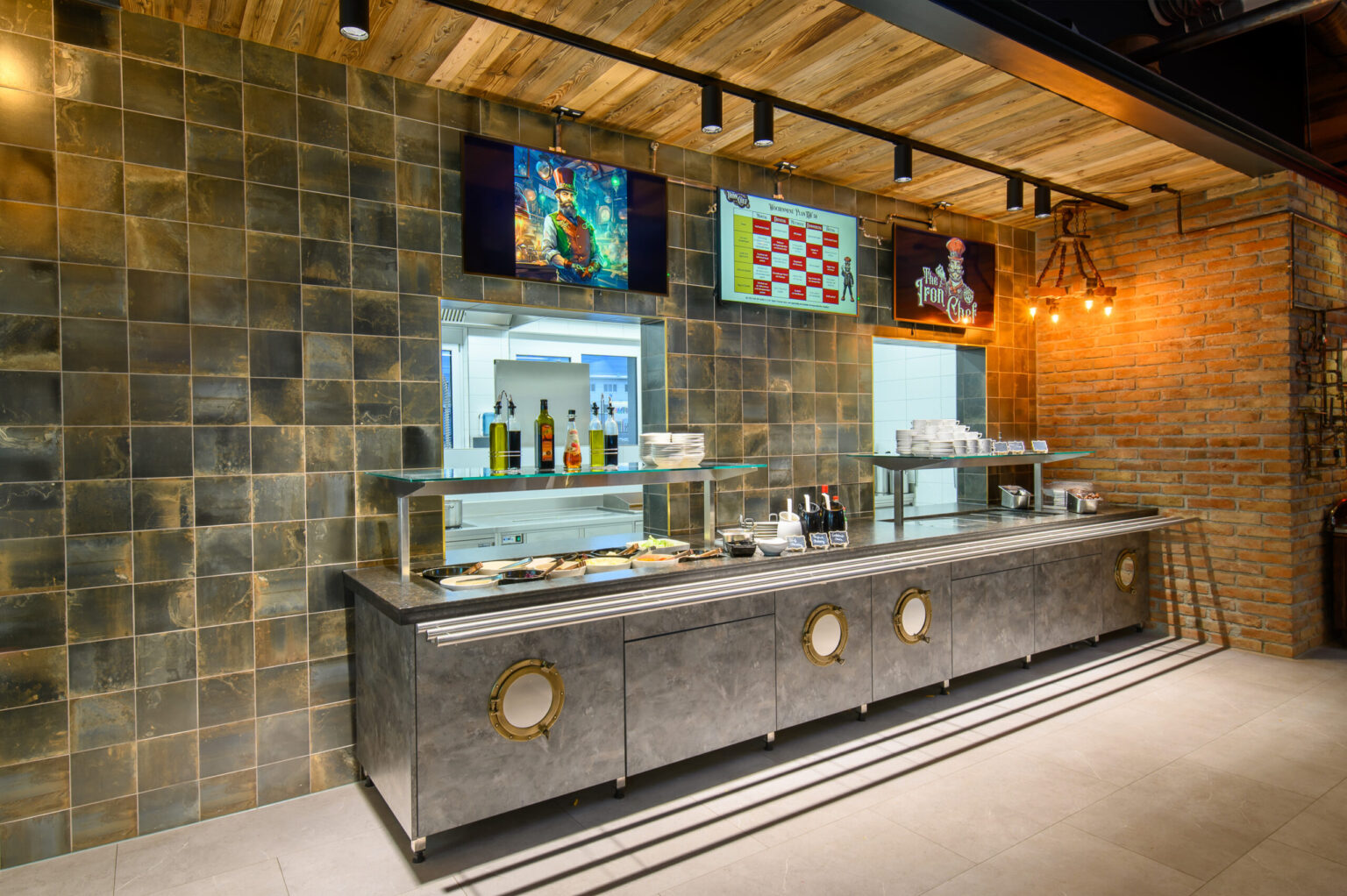 Ein eleganter Gastronomiebereich mit einer modernen Theke und großen TV-Bildschirmen zur Anzeige von Menüs und Specials. Diese Ausstattung wurde von FHE GASTRO geliefert, das für die Bereitstellung innovativer und funktionaler Gastro-Lösungen bekannt ist, die den Betrieb in Restaurants und Bars optimieren.