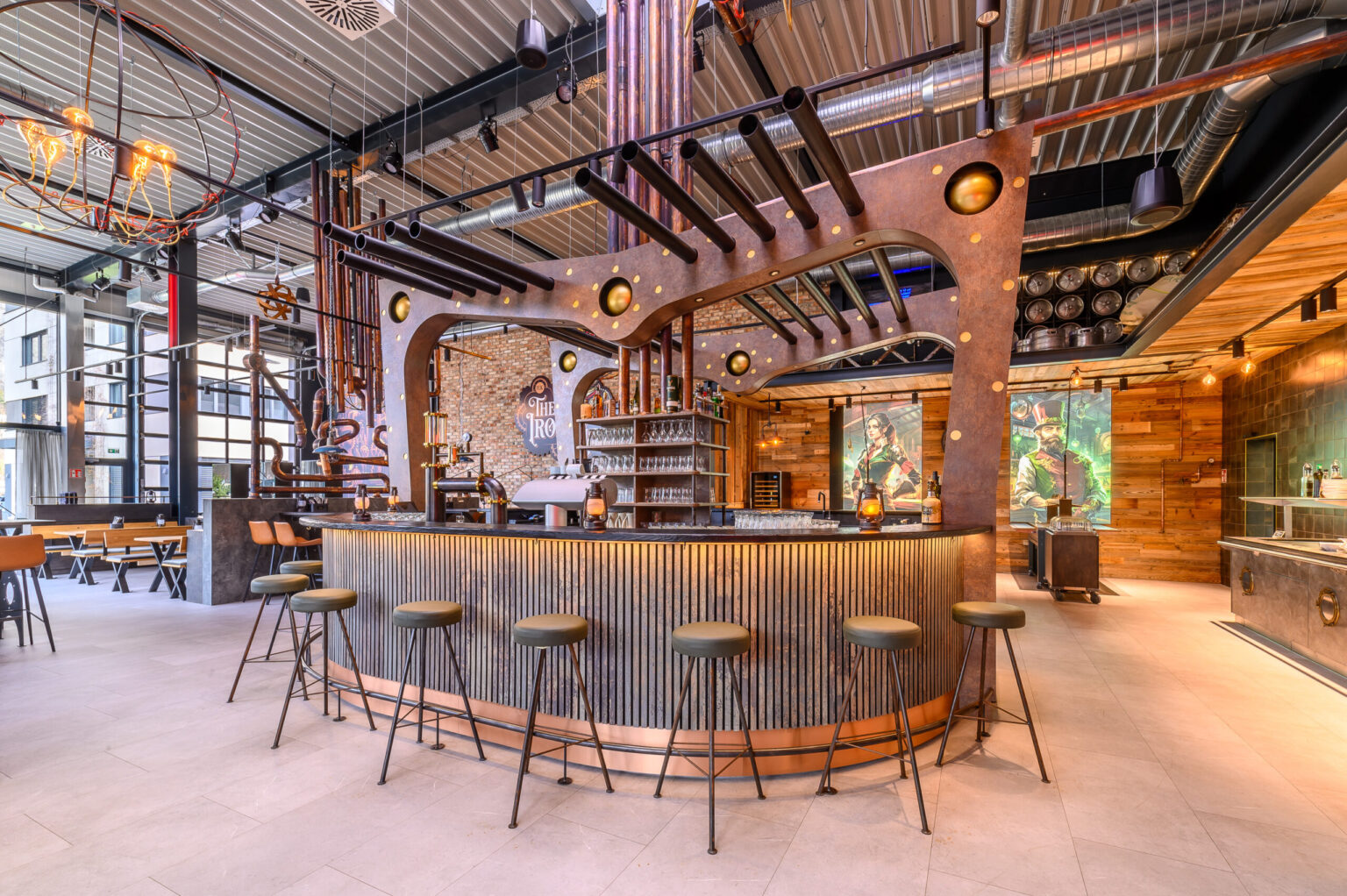 Blick auf einen Barbereich mit auffälligem Steampunk-Design, das durch industrielle Rohre, metallische Akzente und eine außergewöhnliche Barstruktur ergänzt wird. FHE GASTRO liefert hochwertige Gastro-Möbel und Geräte, die dieses einzigartige Design möglich machen.