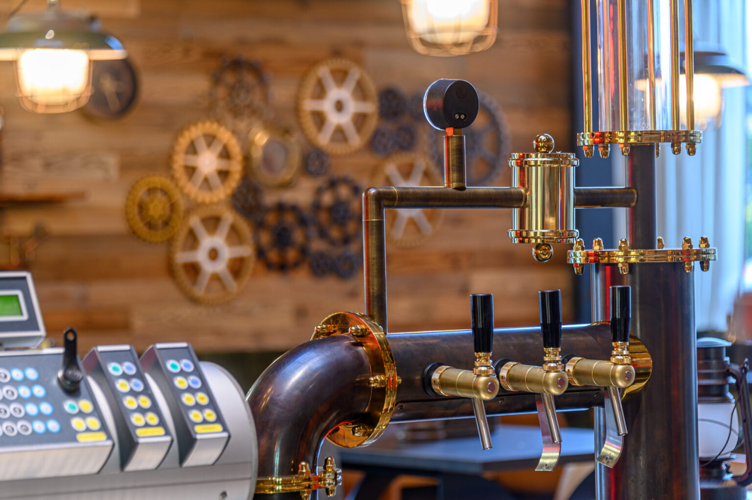 Iron Chef-6680 Edle Zapfanlage von FHE GASTRO mit mehreren Hähnen und einer polierten Metallverkleidung in einer rustikalen Gastroumgebung – ideal für den Ausschank in Brauereien und modernen Bars.