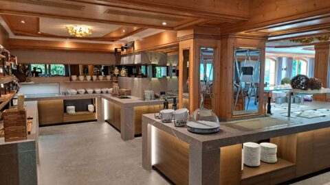 Platzlhof 2023 (13) FHE GASTRO bietet hochwertige Buffeteirichtungen mit eleganten Granitarbeitsplatten und maßgeschneiderten Möbeln. Das Bild zeigt eine großzügige Buffetstation in einem modernen Gastronomiebereich, ausgestattet mit stilvollen Regalen und praktischen Aufbewahrungslösungen. Die Atmosphäre ist warm und einladend, ideal für professionelle Gastronomiebetriebe.