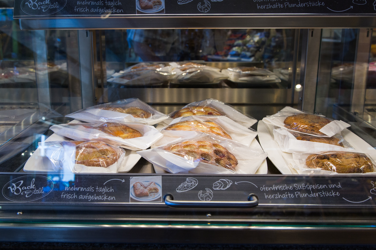 Nahaufnahme von frisch verpackten Gebäckstücken und Gebäck aus der Backstube im Sutterlüty Supermarkt. FHE GASTRO unterstützt Einzelhändler mit maßgeschneiderten Backstationen und Präsentationslösungen für Supermärkte.