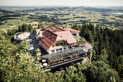 Blaue Burg Falkenstein AUSSEN Luftaufnahme des Botique-Hotels Blaue Burg mit einer modernen Terrasse, die über den Felsen in den Bergen schwebt und einen atemberaubenden Blick auf die umliegende Landschaft bietet. FHE GASTRO liefert maßgeschneiderte Gastronomiemöbel und Einrichtungen, die perfekt in einzigartige Umgebungen wie dieses Hotel passen.